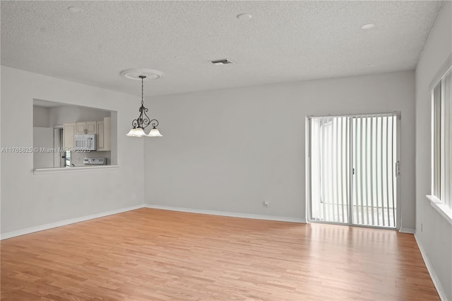 spare room featuring visible vents, light wood-type flooring, and baseboards