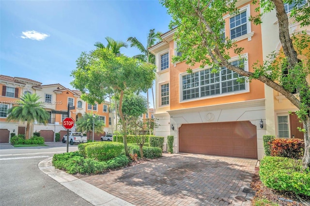 616 NE Venezia Ln Unit 616, Boca Raton, FL 33487 - view of front of home featuring stucco siding, decorative driveway, and a garage