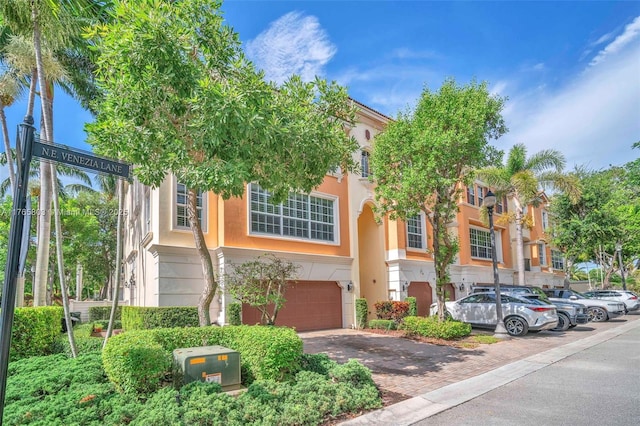 616 NE Venezia Ln Unit 616, Boca Raton, FL 33487 - view of front facade featuring stucco siding, decorative driveway, and a garage