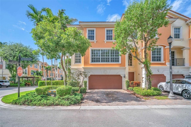 616 NE Venezia Ln Unit 616, Boca Raton, FL 33487 - view of property with a tiled roof, a garage, driveway, and stucco siding