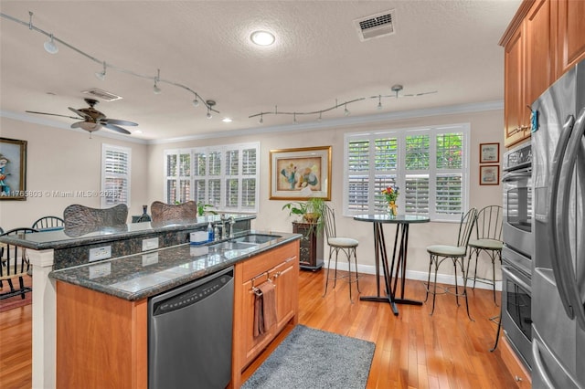 616 NE Venezia Ln Unit 616, Boca Raton, FL 33487 - kitchen with visible vents, a center island with sink, brown cabinets, stainless steel appliances, and a sink