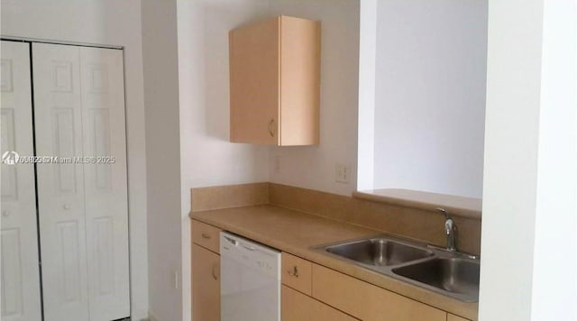 kitchen with dishwasher, light countertops, light brown cabinetry, and a sink