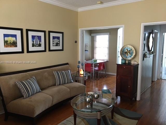 living room with baseboards, wood finished floors, and crown molding