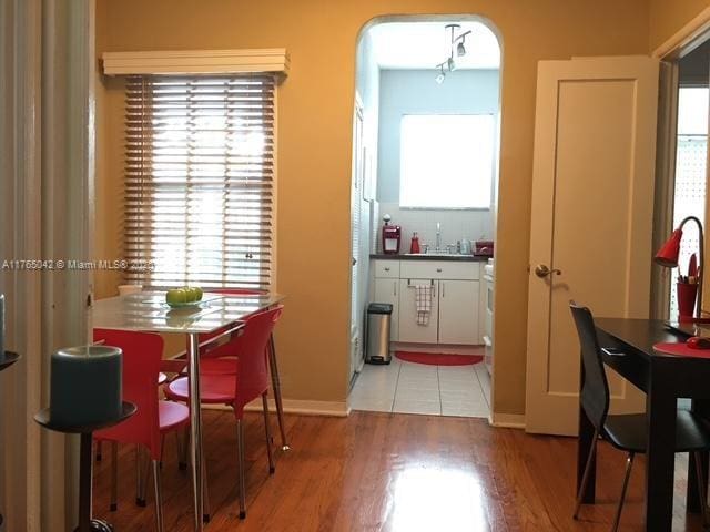 dining room with light wood-style flooring, baseboards, and a healthy amount of sunlight