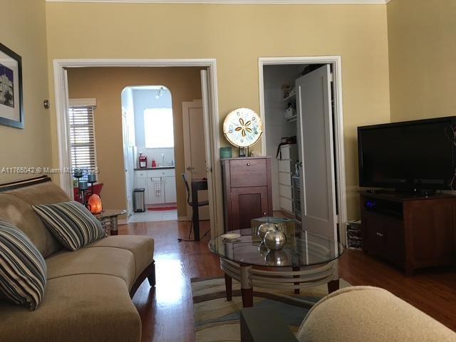 living room with arched walkways and wood finished floors