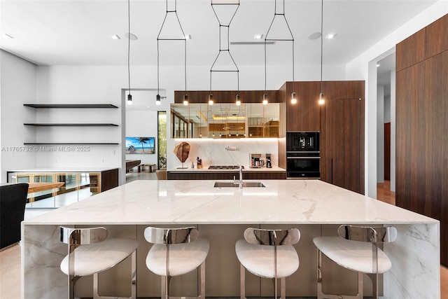 22 Isla Bahia Dr, Fort Lauderdale, FL 33316 - kitchen featuring a spacious island, light stone countertops, decorative backsplash, modern cabinets, and a sink