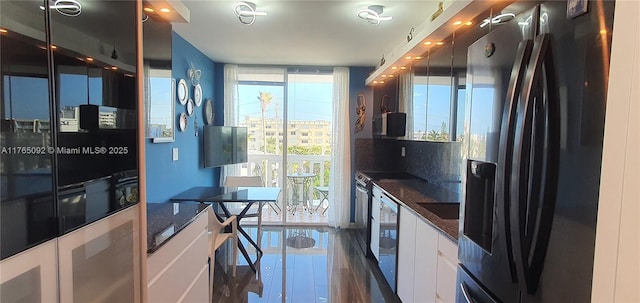 8530 Byron Ave Unit 502, Miami Beach, FL 33141 - kitchen featuring black fridge with ice dispenser, white cabinets, and dark stone counters