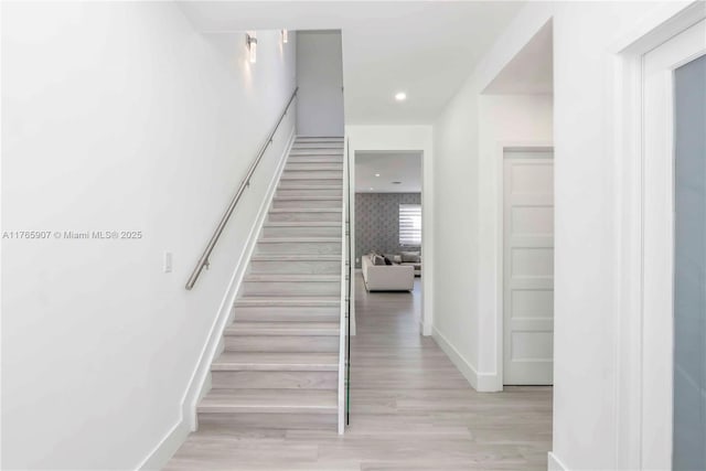 stairway featuring recessed lighting, baseboards, and wood finished floors