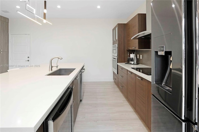 kitchen with a sink, light countertops, modern cabinets, and stainless steel appliances