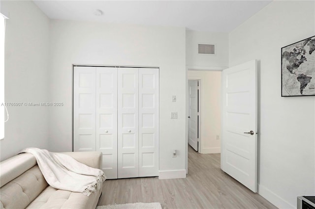 sitting room featuring visible vents, light wood-type flooring, and baseboards