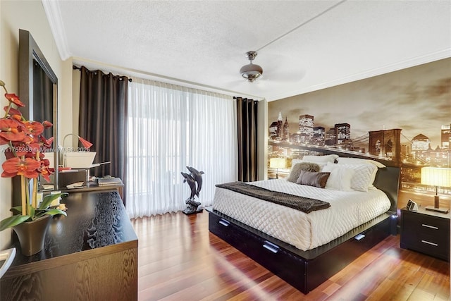 410 Golden Isles Dr Unit 603, Hallandale Beach, FL 33009 - bedroom with ceiling fan, a textured ceiling, wood finished floors, and crown molding