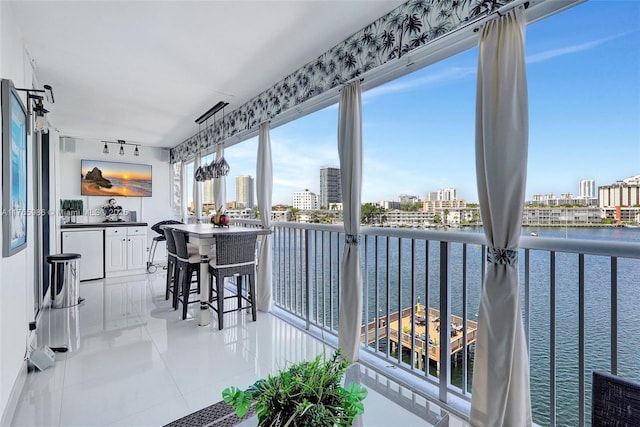 410 Golden Isles Dr Unit 603, Hallandale Beach, FL 33009 - sunroom featuring track lighting, a view of city, and a water view