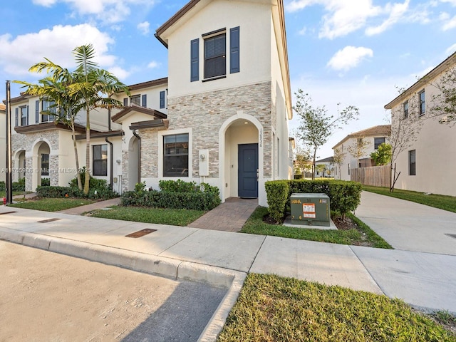 view of front of home featuring stone siding and stucco siding