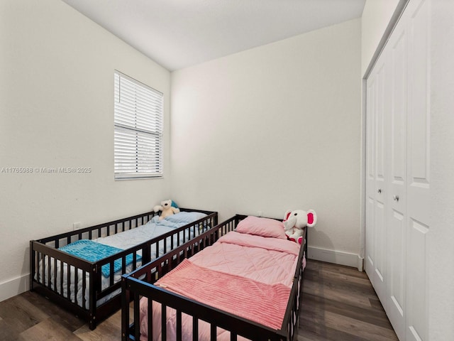 bedroom featuring a closet, baseboards, and wood finished floors