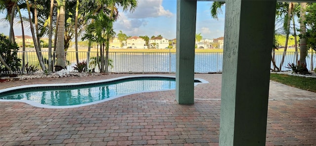 view of pool with a patio area, a water view, fence, and a fenced in pool