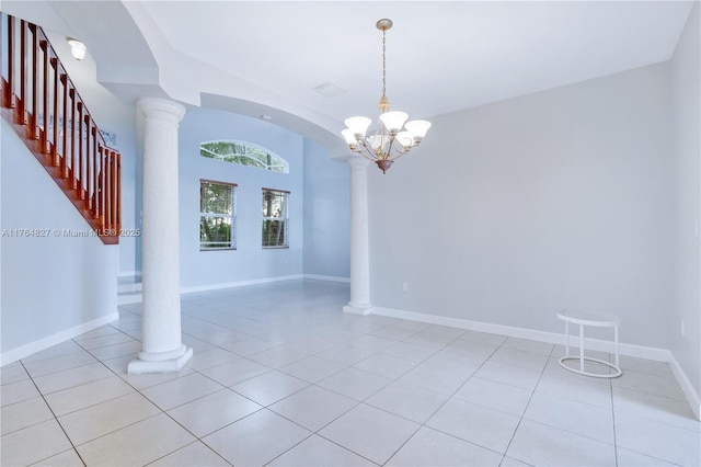 unfurnished room with decorative columns, light tile patterned flooring, and a chandelier