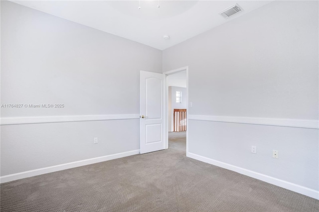 carpeted spare room with baseboards and visible vents
