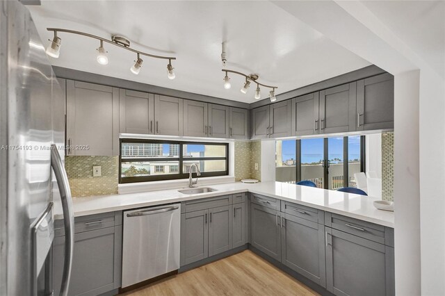 6820 Indian Creek Dr Unit 9A, Miami Beach, FL 33141 - kitchen with light countertops, light wood-style flooring, stainless steel appliances, a sink, and gray cabinetry