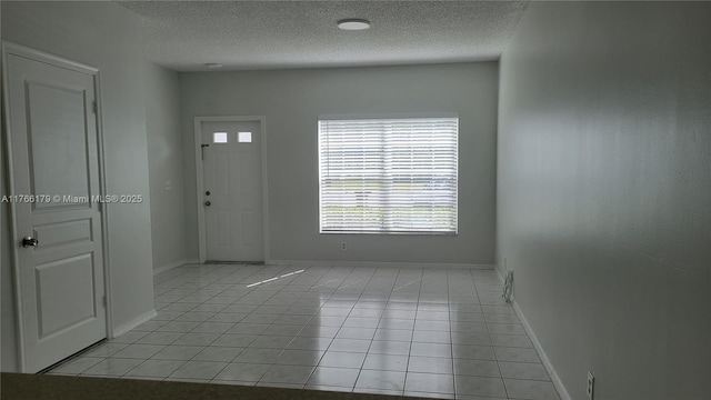 16731 Hemingway Dr, Weston, FL 33326 - foyer featuring light tile patterned flooring, a textured ceiling, and baseboards