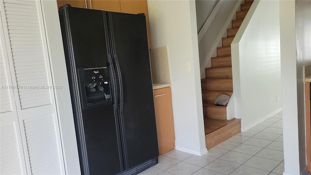 16731 Hemingway Dr, Weston, FL 33326 - kitchen featuring black fridge, light tile patterned floors, light countertops, and baseboards