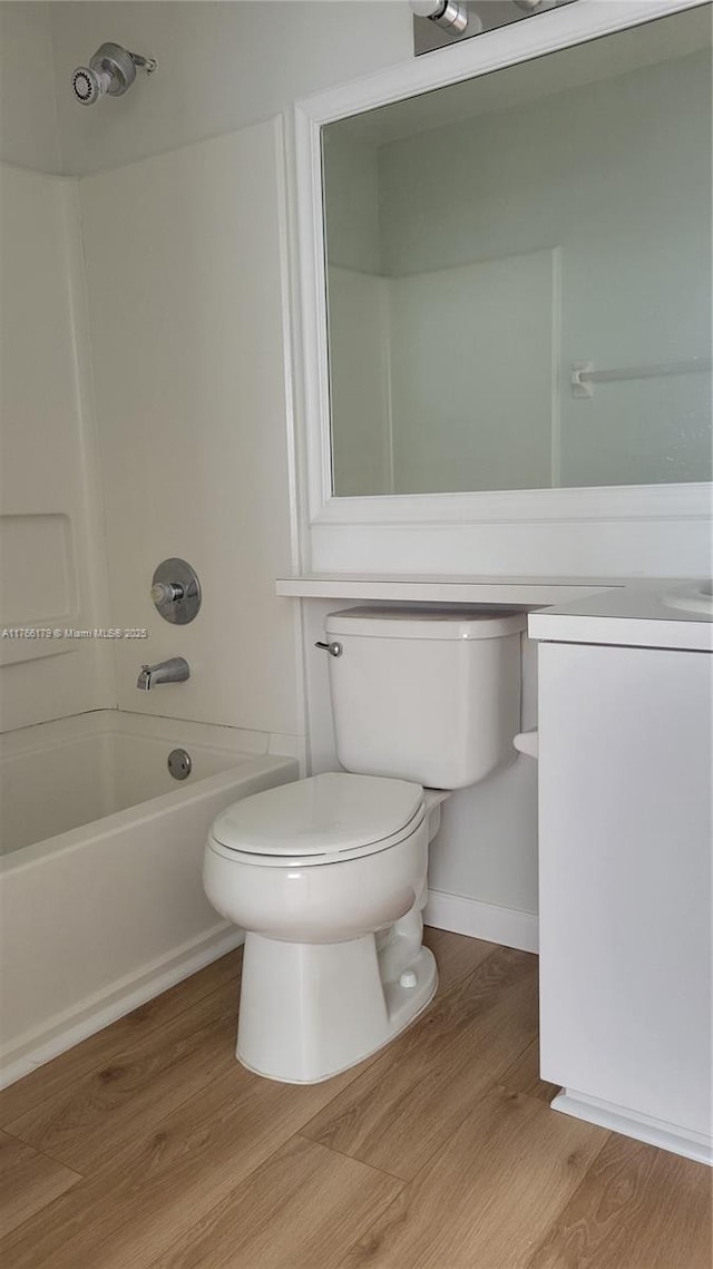 16731 Hemingway Dr, Weston, FL 33326 - bathroom featuring washtub / shower combination, wood finished floors, toilet, and vanity