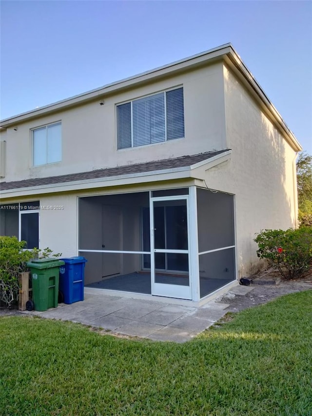 16731 Hemingway Dr, Weston, FL 33326 - back of house featuring a patio area, a lawn, stucco siding, and a sunroom