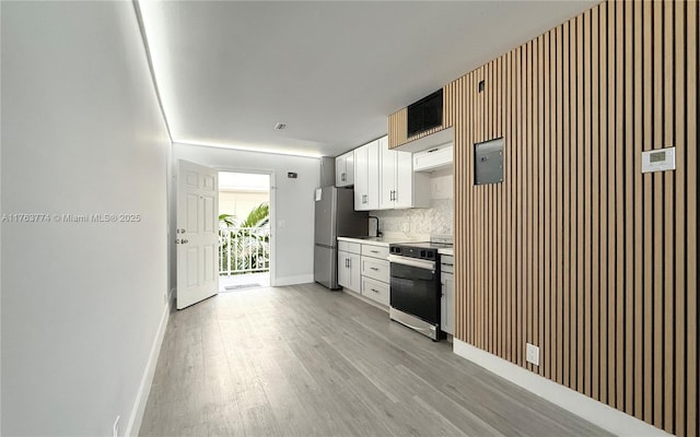 1770 E Las Olas Blvd Unit 302, Fort Lauderdale, FL 33301 - kitchen with stove, freestanding refrigerator, light wood finished floors, white cabinets, and baseboards