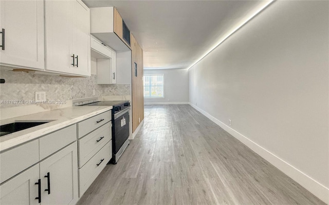 1770 E Las Olas Blvd Unit 302, Fort Lauderdale, FL 33301 - kitchen featuring electric range, light wood-style flooring, backsplash, light countertops, and baseboards