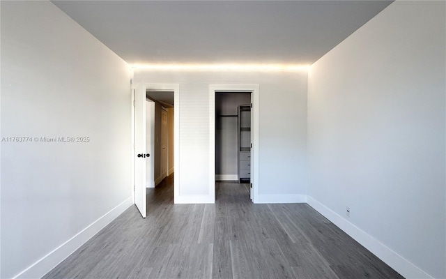 1770 E Las Olas Blvd Unit 302, Fort Lauderdale, FL 33301 - unfurnished bedroom featuring dark wood finished floors, baseboards, a spacious closet, and a closet