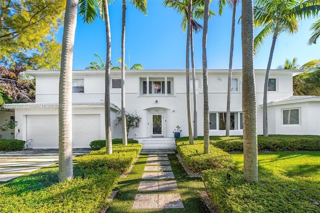 view of property featuring driveway, stucco siding, and an attached garage