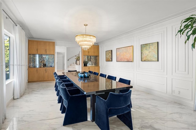 dining room with stairs, ornamental molding, a chandelier, marble finish floor, and a decorative wall