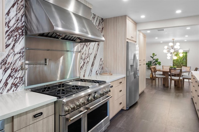 kitchen with light brown cabinets, light countertops, wall chimney range hood, and stainless steel appliances