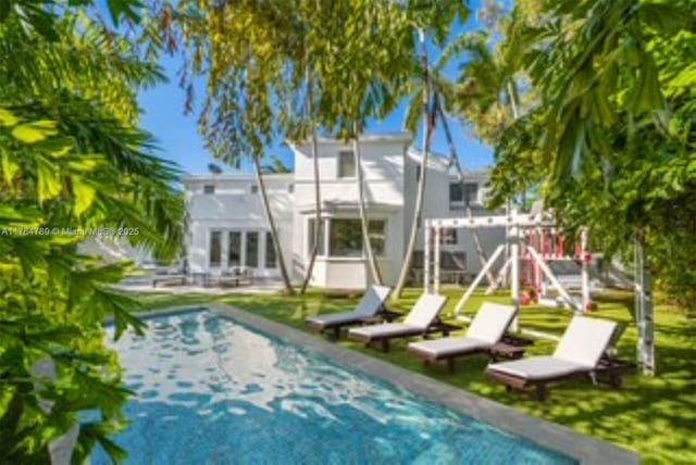 rear view of property with an outdoor pool