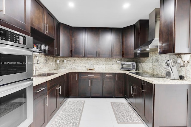 18650 SW 127th Ct, Miami, FL 33177 - kitchen featuring wall chimney range hood, stainless steel double oven, black electric cooktop, tasteful backsplash, and dark brown cabinetry