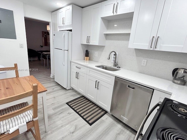kitchen with a sink, black electric range, stainless steel dishwasher, freestanding refrigerator, and light countertops