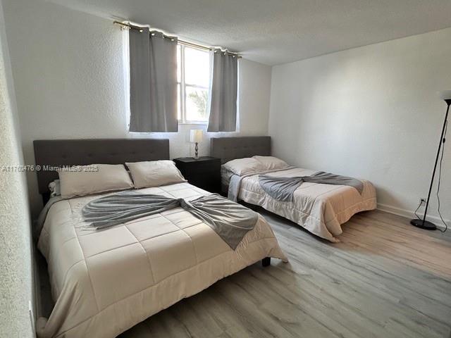 bedroom with wood finished floors and baseboards