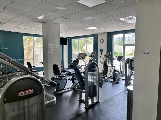 workout area with a wealth of natural light, a drop ceiling, and visible vents