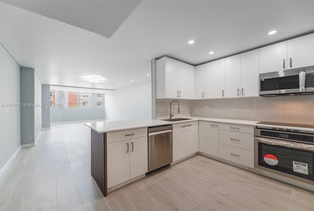 1710 NE 191st St Unit 315-3, Miami, FL 33179 - kitchen featuring tasteful backsplash, light countertops, a peninsula, stainless steel appliances, and a sink