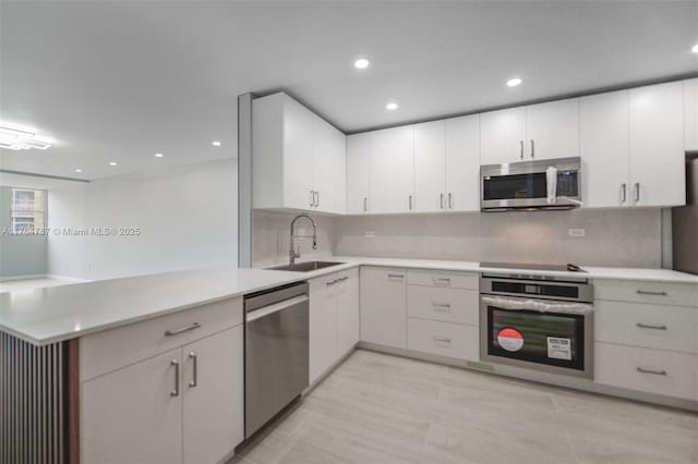 1710 NE 191st St Unit 315-3, Miami, FL 33179 - kitchen featuring a sink, a peninsula, light countertops, and stainless steel appliances