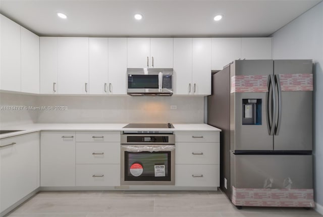 1710 NE 191st St Unit 315-3, Miami, FL 33179 - kitchen with recessed lighting, stainless steel appliances, white cabinets, and light countertops