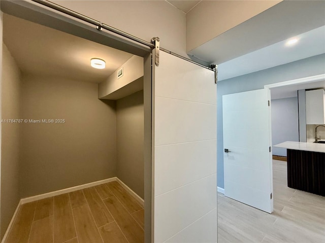 1710 NE 191st St Unit 315-3, Miami, FL 33179 - walk in closet featuring a barn door, light wood-style flooring, visible vents, and a sink