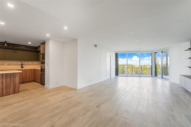 1000 Quayside Ter Unit 903, Miami, FL 33138 - unfurnished living room with light wood-type flooring, visible vents, a sink, recessed lighting, and a wall of windows