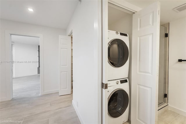 1000 Quayside Ter Unit 903, Miami, FL 33138 - clothes washing area featuring light wood-type flooring, visible vents, stacked washing maching and dryer, baseboards, and laundry area