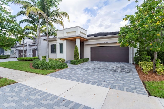 view of front of home featuring a garage, stucco siding, and decorative driveway