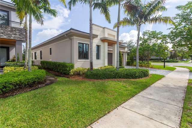 view of property exterior featuring a lawn, driveway, and stucco siding