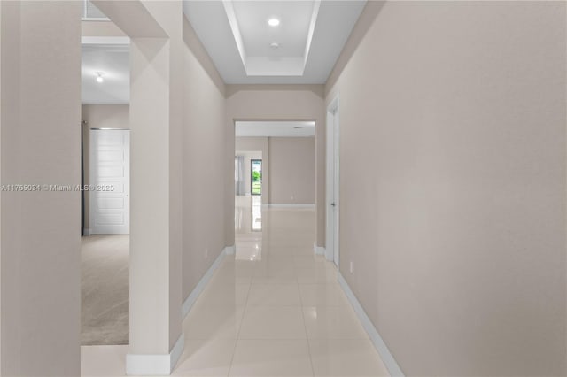 hallway featuring baseboards and light tile patterned floors