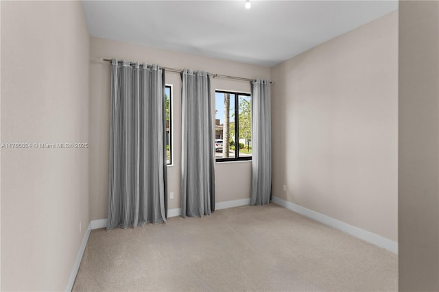 unfurnished room featuring carpet flooring and baseboards
