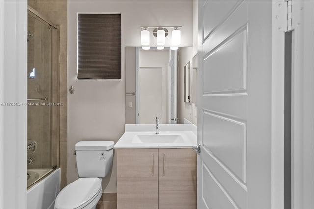 full bathroom featuring toilet, bath / shower combo with glass door, and vanity