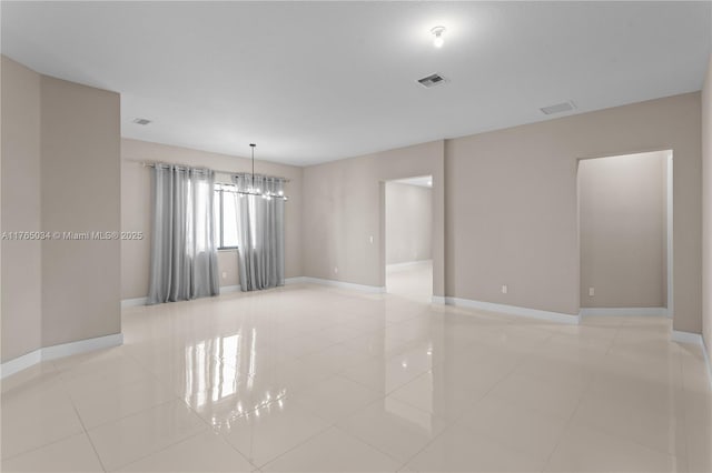 spare room with visible vents, baseboards, light tile patterned floors, and a chandelier