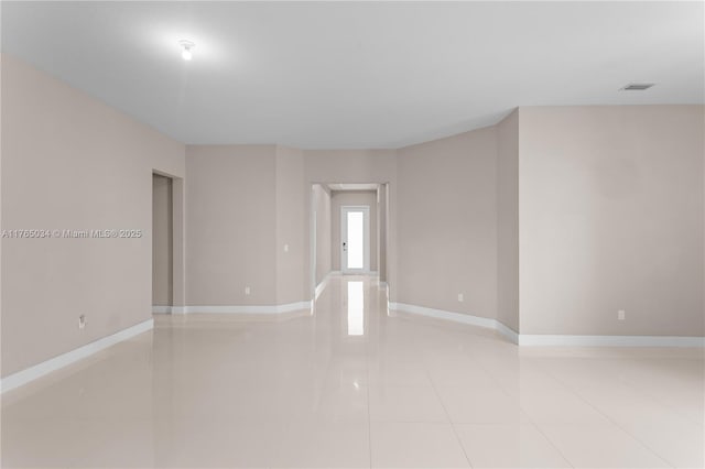 spare room with baseboards, light tile patterned floors, and visible vents